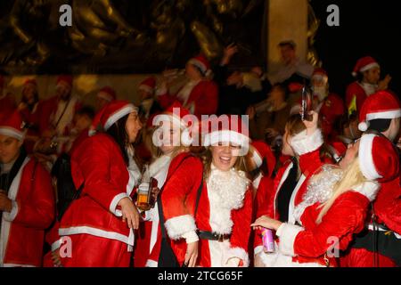 Die Leute nehmen an der SantaCon am Trafalgar Square Teil, bei der sie sich als Weihnachtsmann verkleiden und dann in die Stadt gehen, um Weihnachtsstimmung zu verbreiten. Die Stockfoto