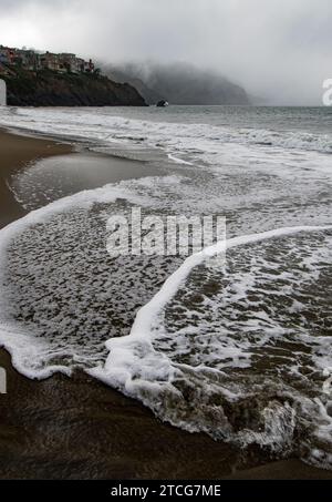 Wellen und Nebel rollt in Baker Beach, San Francisco, Kalifornien Stockfoto