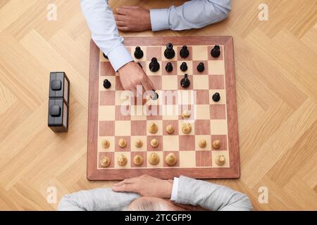 Männer spielen Schach während des Turniers am Holztisch, Blick von oben Stockfoto