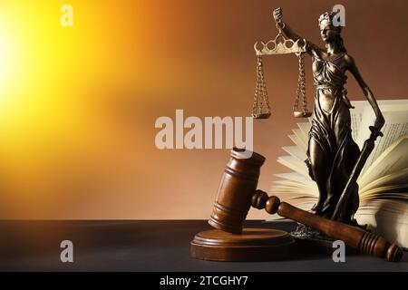 Symbol für eine gerechte Behandlung nach dem Gesetz. Statue von Lady Justice, Hammer und Buch auf schwarzem Tisch, Platz für Text Stockfoto