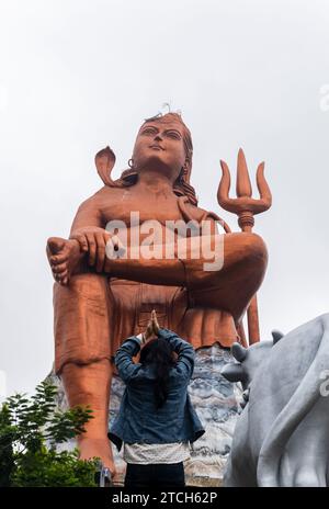 Ein junges Mädchen, das morgens aus einem flachen Winkel der Statue of Believe shiva grüßt, wird an der Glaubensstatue oder Vishwas Swaroopam nat aufgenommen Stockfoto