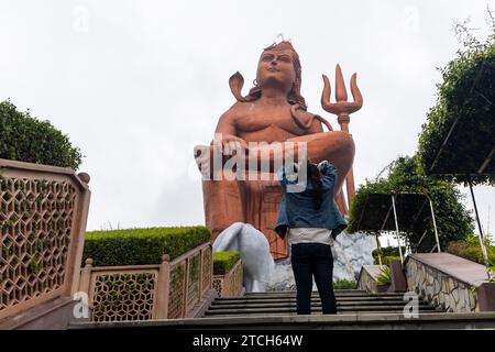 Ein junges Mädchen, das morgens aus einem flachen Winkel der Statue of Believe shiva grüßt, wird an der Glaubensstatue oder Vishwas Swaroopam nat aufgenommen Stockfoto