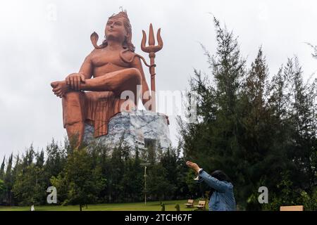 Ein junges Mädchen, das morgens aus einem flachen Winkel der Statue of Believe shiva grüßt, wird an der Glaubensstatue oder Vishwas Swaroopam nat aufgenommen Stockfoto