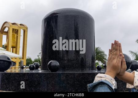 Geweihter grüßt morgens an das religiöse Symbol Shivalinga des hindus Stockfoto