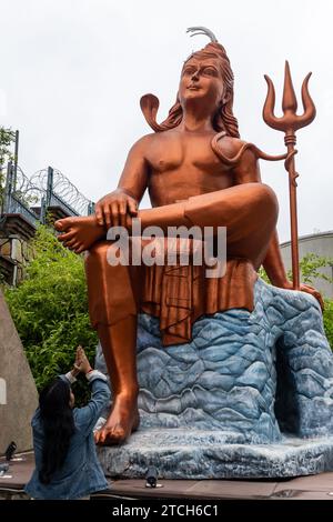 Ein junges Mädchen, das morgens aus flachem Winkel der Statue des hindugottes shiva grüßt, wird an der Statue des Glaubens nathdwara rajasthan india aufgenommen. Stockfoto