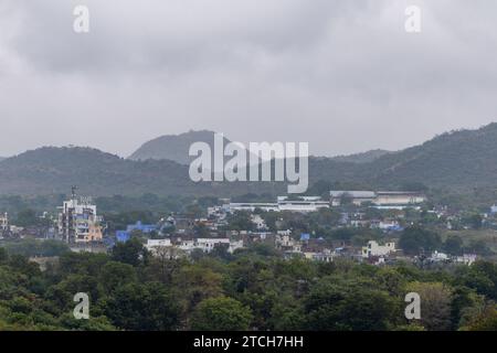 Stadt am Fuße der nebeligen Bergschicht am Morgen aus flachem Winkel Stockfoto