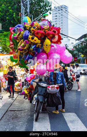 Nha Trang, Vietnam - 18. Januar 2023: Vietnamesische Ballonverkäufer in der Nacht in der Nähe der Straße in Tet, Neujahrsmonat Stockfoto