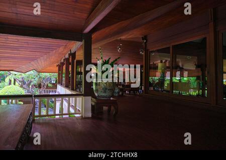 Blick auf eine der Terrassen mit dunkler Holztäfelung überall. Im Nai Lert Park Heritage Home in Bangkok, Thailand. Stockfoto