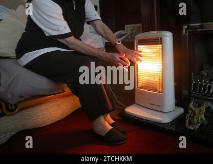 Aktenfoto vom 19./11/14 einer älteren Dame mit elektrischem Feuer zu Hause in Liverpool. Mehr als eine Million der gefährdetsten Erwachsenen Großbritanniens werden an Weihnachten in kalten und feuchten Häusern der „Dickensianer“ leben, warnten Aktivisten. Etwa 16 % der Erwachsenen, also 8,3 Millionen Menschen, leben in kalten und feuchten Häusern und sind den gesundheitlichen Komplikationen ausgesetzt, die durch das Leben in Kraftstoffarmut entstehen, so die Kampagne warm This Winter. Ausgabedatum: Mittwoch, 13. Dezember 2023. Stockfoto