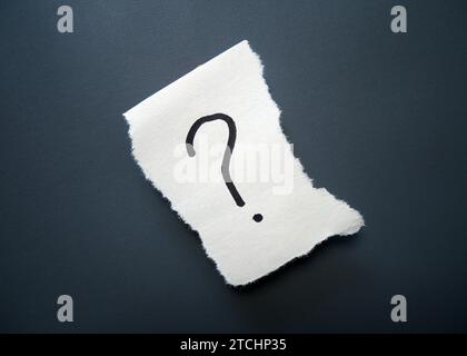 Gerissenes Papier mit Fragezeichensymbol auf gelbem Hintergrund und Kopierraum Stockfoto