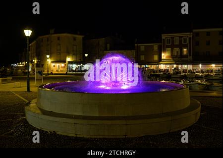 Cres, Kroatien - 8. April 2023: Detail eines Brunnens auf dem Hauptplatz in der Nähe des Hafens in Cres mit farbigen Lichtern Stockfoto