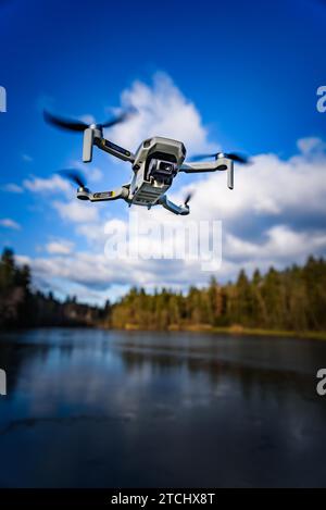 Graz, Österreich, 29. Dezember 2019. DJI Mavic Mini Drohne fliegt in der Landschaft über dem gefrorenen See an sonnigen Wintertagen. Drohne fliegt Stockfoto