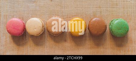 Traditionelle französische bunte Macarons in einer Reihe auf dem Tisch. Bunte Kekse Stockfoto