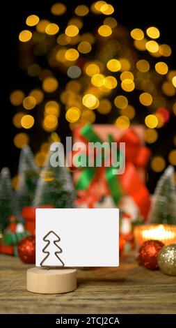 Weihnachtsgeschenkbox Geschenk mit horizontalem leerem weißem Papier für Grußkarte oder Einladungskarte mit Kopierraum für die Weihnachtsfeier Stockfoto