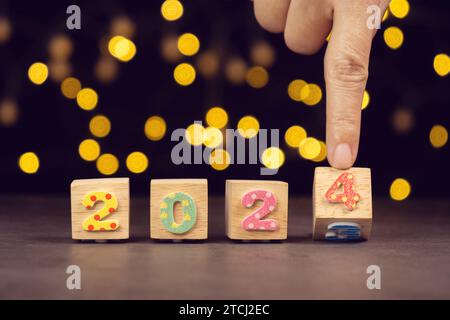Handdrehbarer Holzwürfelblock aus dem Jahr 2023 bis zum Jahr 2024. Beginn und Beginn des neuen Jahres 2024 für Silvester-Countdown Stockfoto