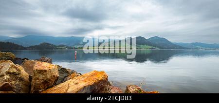 Ein malerischer Blick auf majestätische Berggipfel, die sich im ruhigen blauen Wasser eines großen Sees spiegeln Stockfoto