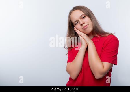 Hellhaariges Teenager-Mädchen in einem roten T-Shirt auf weißem Hintergrund Stockfoto