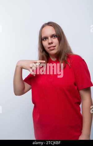 Weißes Mädchen mit braunen Haaren trägt ein rotes T-Shirt Stockfoto