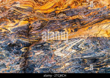 Hintergrund aus Naturmarmor mit Rissen und bunten Schichten in Second Valley, South Australia Stockfoto