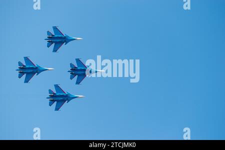 Vier Sukhoi Su-27 Flanker-Kampfjets der russischen Luftwaffe fliegen in einer atemberaubenden Formation gegen einen klaren blauen Himmel. Stockfoto