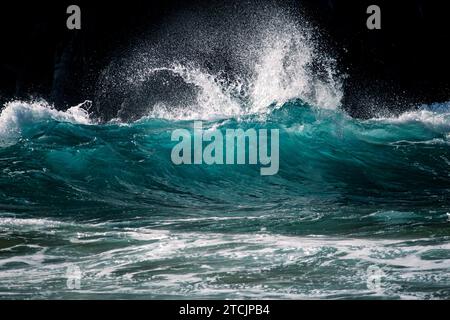 Wellen gegen Felsen Stockfoto