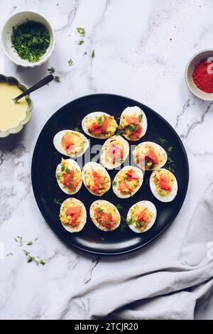 Selbstgemachte abgestandene Eier mit Lachs auf schwarzem Hintergrund. Stockfoto