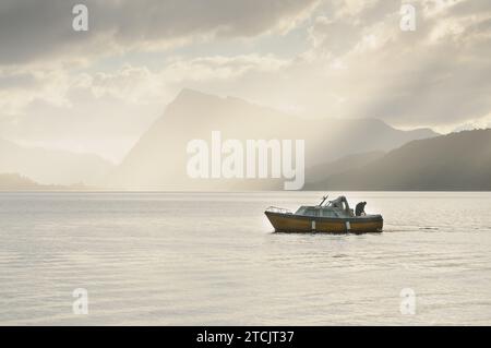 Angler in einem Boot inmitten der Berge Stockfoto