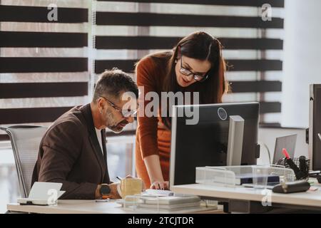 Erfolgreiches multinationales Business-Team, das in einer Unternehmenszentrale zusammenarbeitet Stockfoto