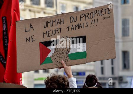 Marseille, Frankreich. Dezember 2023. Eine palästinensische Demonstrantin hält während der Demonstration ein Plakat mit der Aufschrift „die Ummah des Propheten stirbt nie“. Die Demonstration für einen Waffenstillstand im Gazastreifen fand nach einer Entscheidung des Verwaltungsgerichts zunächst vom Polizeipräsidium Bouches-du-RhÃ wegen ernsthafter Gefahr einer Störung der öffentlichen Ordnung verboten statt. (Credit Image: © Gerard Bottino/SOPA Images via ZUMA Press Wire) NUR REDAKTIONELLE VERWENDUNG! Nicht für kommerzielle ZWECKE! Stockfoto