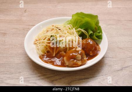 Spaghetti Dressing gebratener Fleischbällchen gefüllter Käse in Ketchup-Sauce und Cossalat auf Teller Stockfoto