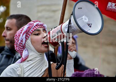 Marseille, Frankreich. Dezember 2023. Eine palästinensische Demonstrantin mit Megaphon singt während der Demonstration Slogans. Die Demonstration für einen Waffenstillstand im Gazastreifen fand nach einer Entscheidung des Verwaltungsgerichts zunächst vom Polizeipräsidium Bouches-du-RhÃ wegen ernsthafter Gefahr einer Störung der öffentlichen Ordnung verboten statt. (Credit Image: © Gerard Bottino/SOPA Images via ZUMA Press Wire) NUR REDAKTIONELLE VERWENDUNG! Nicht für kommerzielle ZWECKE! Stockfoto