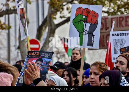 Marseille, Frankreich. Dezember 2023. Ein palästinensischer Demonstrant hält ein Plakat mit geballter Faust in den Farben Palästinas. Die Demonstration für einen Waffenstillstand im Gazastreifen fand nach einer Entscheidung des Verwaltungsgerichts zunächst vom Polizeipräsidium Bouches-du-RhÃ wegen ernsthafter Gefahr einer Störung der öffentlichen Ordnung verboten statt. (Credit Image: © Gerard Bottino/SOPA Images via ZUMA Press Wire) NUR REDAKTIONELLE VERWENDUNG! Nicht für kommerzielle ZWECKE! Stockfoto