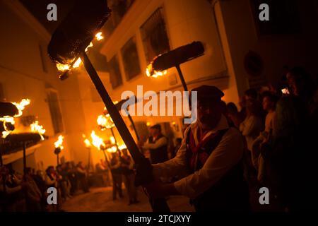 Die Dorfbewohner halten Fackeln auf einer Straße, während sie an der Feier der „Divina Pastora“-Virgin-Prozession teilnehmen. Am Vorabend des Festes von Santa Lucia in dem kleinen Dorf Casarabonela nehmen die Dorfbewohner an der alten Feier von „Los Rondeles“ während der Weihnachtszeit jeden Abend des 12. Dezember Teil und tragen brennende Korbkörbe (auch bekannt als „Rondeles“), die in Öl getränkt sind. Entlang der Straßen wird die Jungfrau von Los Rondeles von den Gläubigen in einem Ritual aus Licht und Feuer geehrt, um für die Ernte zu danken. Stockfoto