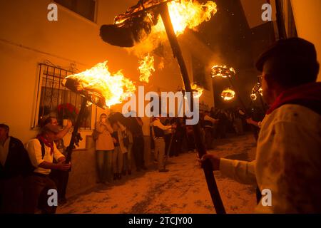 Die Dorfbewohner halten Fackeln auf einer Straße, während sie an der Feier der „Divina Pastora“-Virgin-Prozession teilnehmen. Am Vorabend des Festes von Santa Lucia in dem kleinen Dorf Casarabonela nehmen die Dorfbewohner an der alten Feier von „Los Rondeles“ während der Weihnachtszeit jeden Abend des 12. Dezember Teil und tragen brennende Korbkörbe (auch bekannt als „Rondeles“), die in Öl getränkt sind. Entlang der Straßen wird die Jungfrau von Los Rondeles von den Gläubigen in einem Ritual aus Licht und Feuer geehrt, um für die Ernte zu danken. Stockfoto