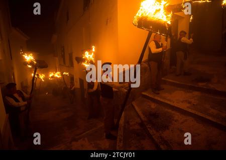 Die Dorfbewohner halten Fackeln auf einer Straße, während sie an der Feier der „Divina Pastora“-Virgin-Prozession teilnehmen. Am Vorabend des Festes von Santa Lucia in dem kleinen Dorf Casarabonela nehmen die Dorfbewohner an der alten Feier von „Los Rondeles“ während der Weihnachtszeit jeden Abend des 12. Dezember Teil und tragen brennende Korbkörbe (auch bekannt als „Rondeles“), die in Öl getränkt sind. Entlang der Straßen wird die Jungfrau von Los Rondeles von den Gläubigen in einem Ritual aus Licht und Feuer geehrt, um für die Ernte zu danken. Stockfoto