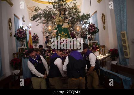 Die Dorfbewohner tragen die Statue der Jungfrau in einer Kapelle, während sie an der Feier der „Divina Pastora“-Virgin-Prozession teilnehmen. Am Vorabend des Festes von Santa Lucia in dem kleinen Dorf Casarabonela nehmen die Dorfbewohner an der alten Feier von „Los Rondeles“ während der Weihnachtszeit jeden Abend des 12. Dezember Teil und tragen brennende Korbkörbe (auch bekannt als „Rondeles“), die in Öl getränkt sind. Entlang der Straßen wird die Jungfrau von Los Rondeles von den Gläubigen in einem Ritual aus Licht und Feuer geehrt, um für die Ernte zu danken. Stockfoto