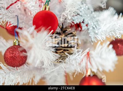 Echter Tannenzapfen im weißen Weihnachtsbaum Stockfoto