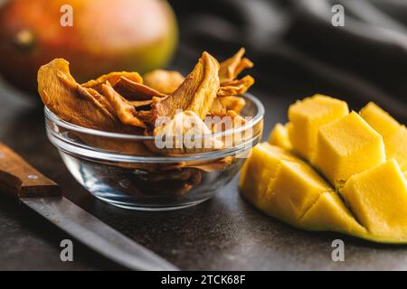 Getrocknete Mangobrüchte in einer Schüssel auf dem schwarzen Tisch. Stockfoto