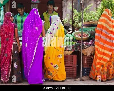 Deorgah, Indien - 8. März 2015: Frauen in typisch farbenfrohen Rajasthani-Kleidern kaufen Obst und Gemüse auf dem überfüllten Marktgebiet der Stadt Stockfoto