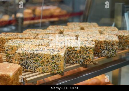 Brot zum Backen von Samen, Kürbis, Sonnenblumen und Sesam. Frisches Gebäck am Schaufenster Stockfoto
