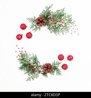 Weihnachtsrahmen aus Tannenzweigen und Baumdekoration auf weißem Hintergrund. Flache Lage, Draufsicht Stockfoto