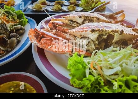 Blick von oben auf Variety Seafood Partytisch mit Jakobsmuscheln, Cockle, Krabben, Muscheln, Garnelen, Flusskrebse auf schwarzem Hintergrund. Meeresfrüchte-Platte auf schwarzem Holztisch Stockfoto
