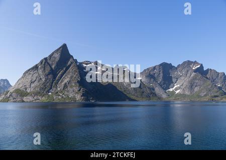 Majestätische Bergkämme der Lofoten, Norwegen, erheben sich über den Gewässern der Nordsee, unter dem Sommerhimmel Stockfoto