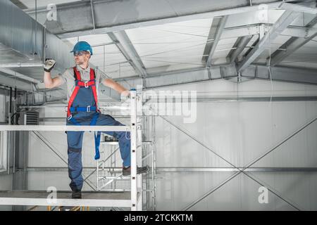 Lagergebäudespezialist, Der Eine Untersuchung Mit Gerüsten Durchführt. HLK-Prüfung. Stockfoto