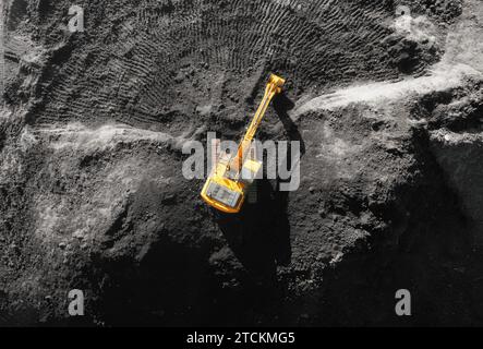 Luftaufnahme eines gelben Baggers, der auf einer Baustelle arbeitet. Stockfoto