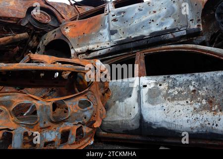 Eine Müllhalde von abgeschossenen und verbrannten Autos als Folge der russischen Invasion in die Ukraine. Krieg in der Ukraine. Nahaufnahme. Stockfoto