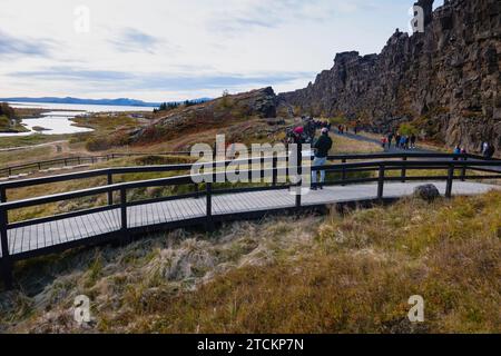 Island, Golden Circle, Thingvellir Nationalpark in Herbstfarben. Der Mittelatlantische Graben zwischen der nordamerikanischen und der eurasischen Platte. Die Almannagja-Schlucht markiert den Rand der nordamerikanischen tektonischen Platte mit Besichtigungstouren. Lake Thingvallavtn auf dem Reykjares Ridge im Rift Valley dahinter. Stockfoto