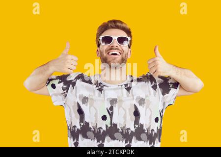 Porträt eines glücklichen jungen Mannes in Sonnenbrille mit Daumen nach oben Stockfoto