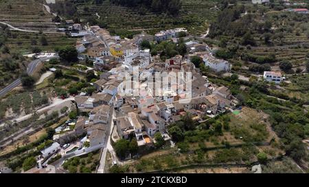 Vollständiger Blick aus der Luft auf die kleine Stadt Benialí inmitten von Feldern im Gallinera-Tal im Norden von Alicante, Spanien. Stadt in Valencia Stockfoto