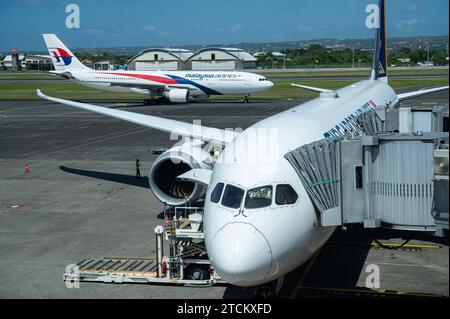 25.07.2023, Denpasar, Bali, Indonesien, Asien - ein Passagierflugzeug der Singapore Airlines vom Typ Boeing 787-10 Dreamliner parkt auf dem internationalen Flughafen I Gusti Ngurah Rai an einem Gate, waehrend im Hintergrund eine Maschine vom Typ Airbus A330 der Malaysia Airlines vorbeirollt. Singapore Airlines ist Mitglied der Star Alliance Luftfahrtallianz, einem internationalen Netzwerk von Fluggesellschaften. *** 25 07 2023, Denpasar, Bali, Indonesien, Asien A Singapore Airlines Boeing 787 10 Dreamliner Passagierflugzeuge parken an einem Gate am I Gusti Ngurah Rai International Airport während a Mal Stockfoto